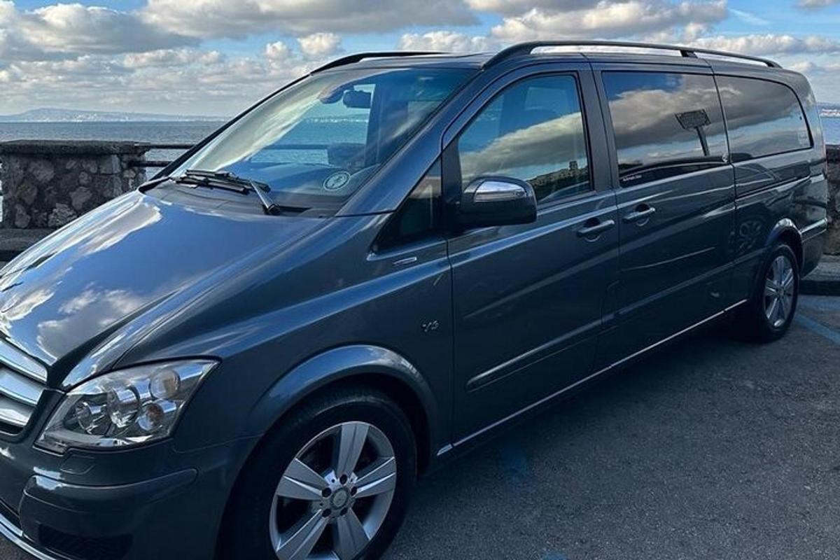 Una camioneta azul estacionada en un estacionamiento cerca del océano.