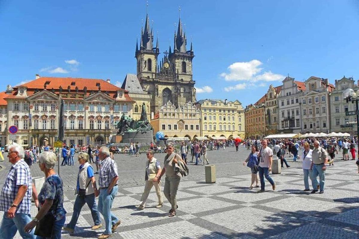 skupina lidí jdoucích po náměstí ve městě