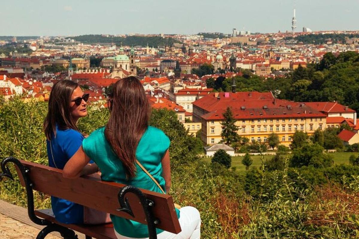 dve ženy sediace na lavičke a pozerajúce sa na mesto
