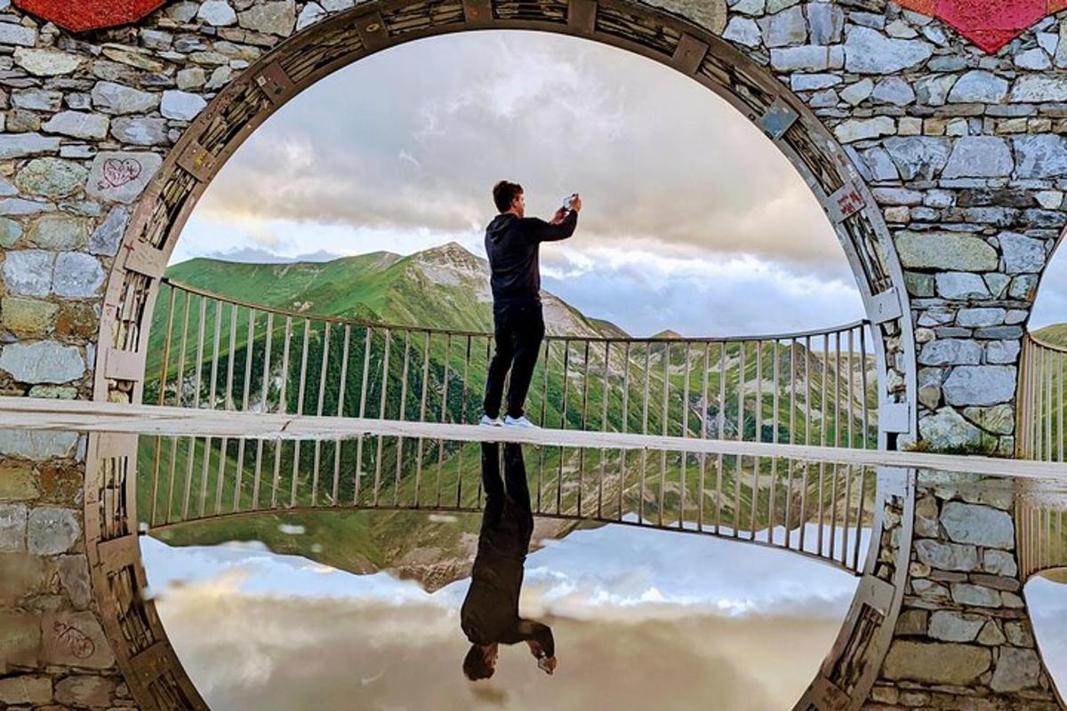 un uomo in piedi su un ponte con un riflesso nell'acqua