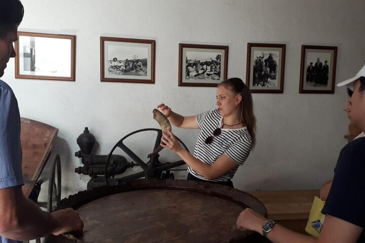 Egy nő egy tárgyat tart a kezében egy szobában, ahol emberek vannak