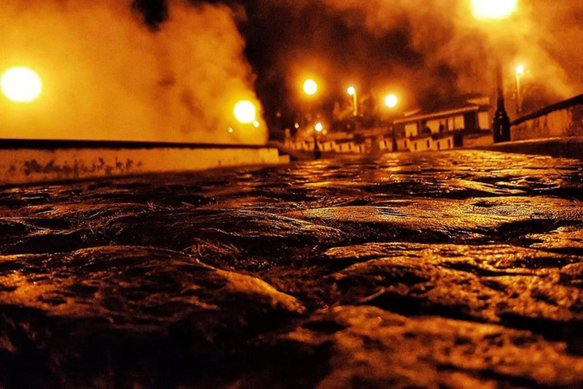 a wet street at night with smoke and lights