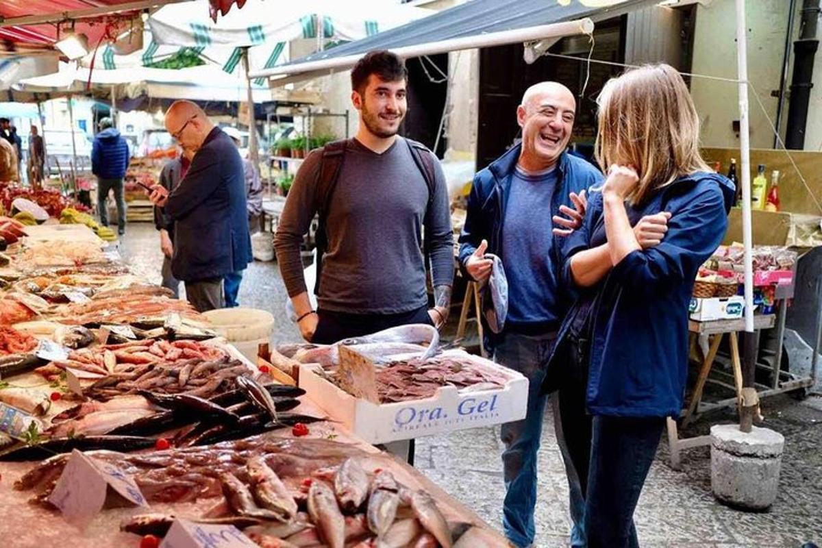 un gruppo di persone in piedi in un mercato con frutti di mare