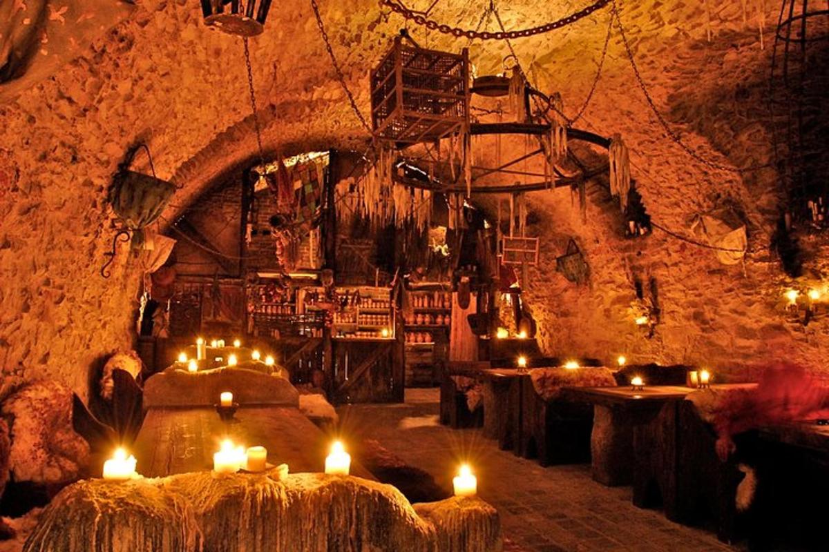 una stanza con tavoli e candele in una grotta