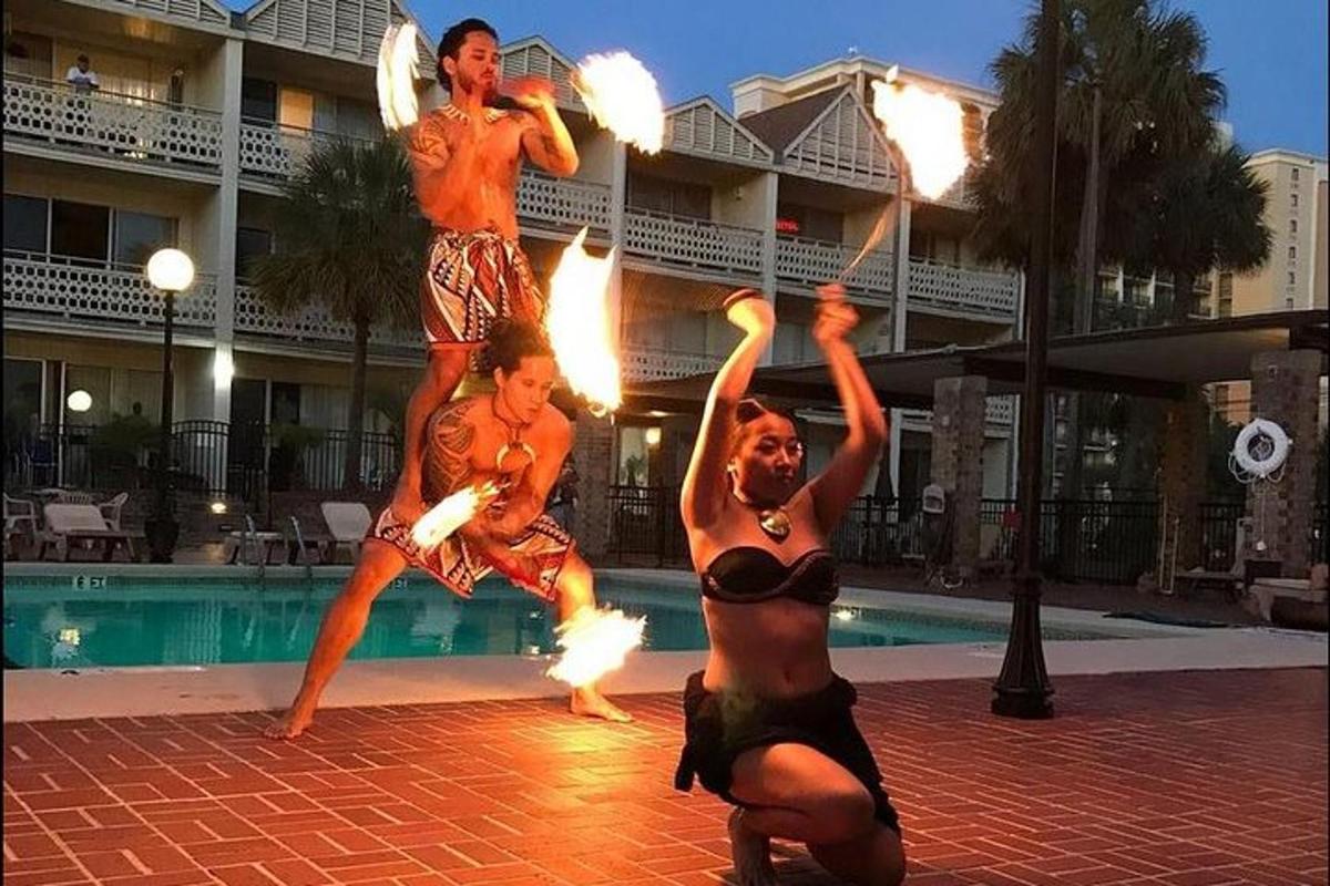 a group of men performing a fire show in front of a pool