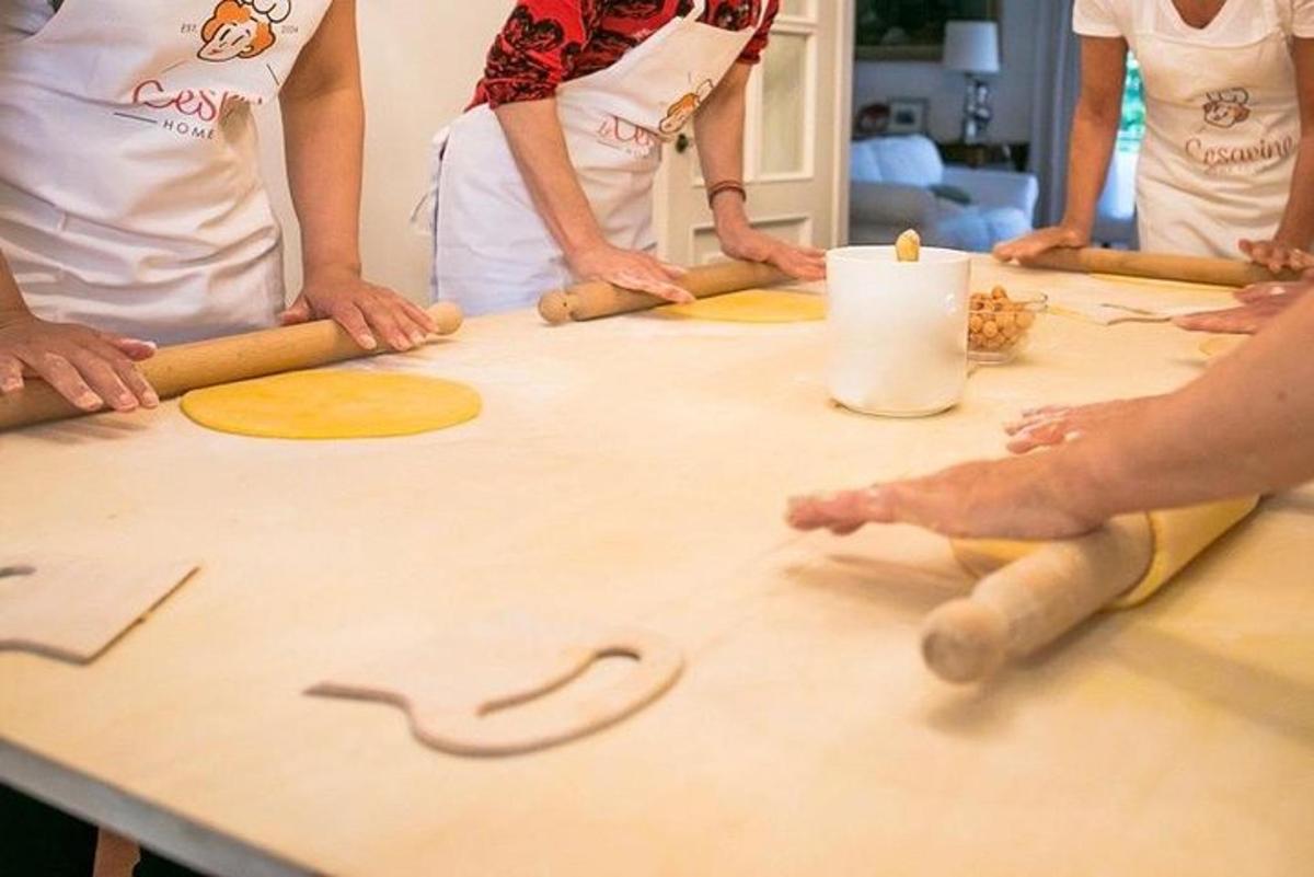 a group of people standing around a table with dough
