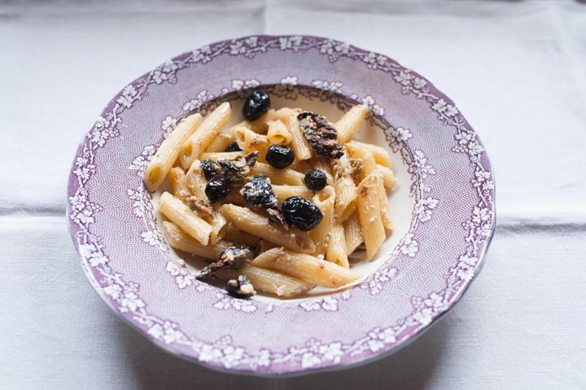 a bowl of pasta with nuts on a table