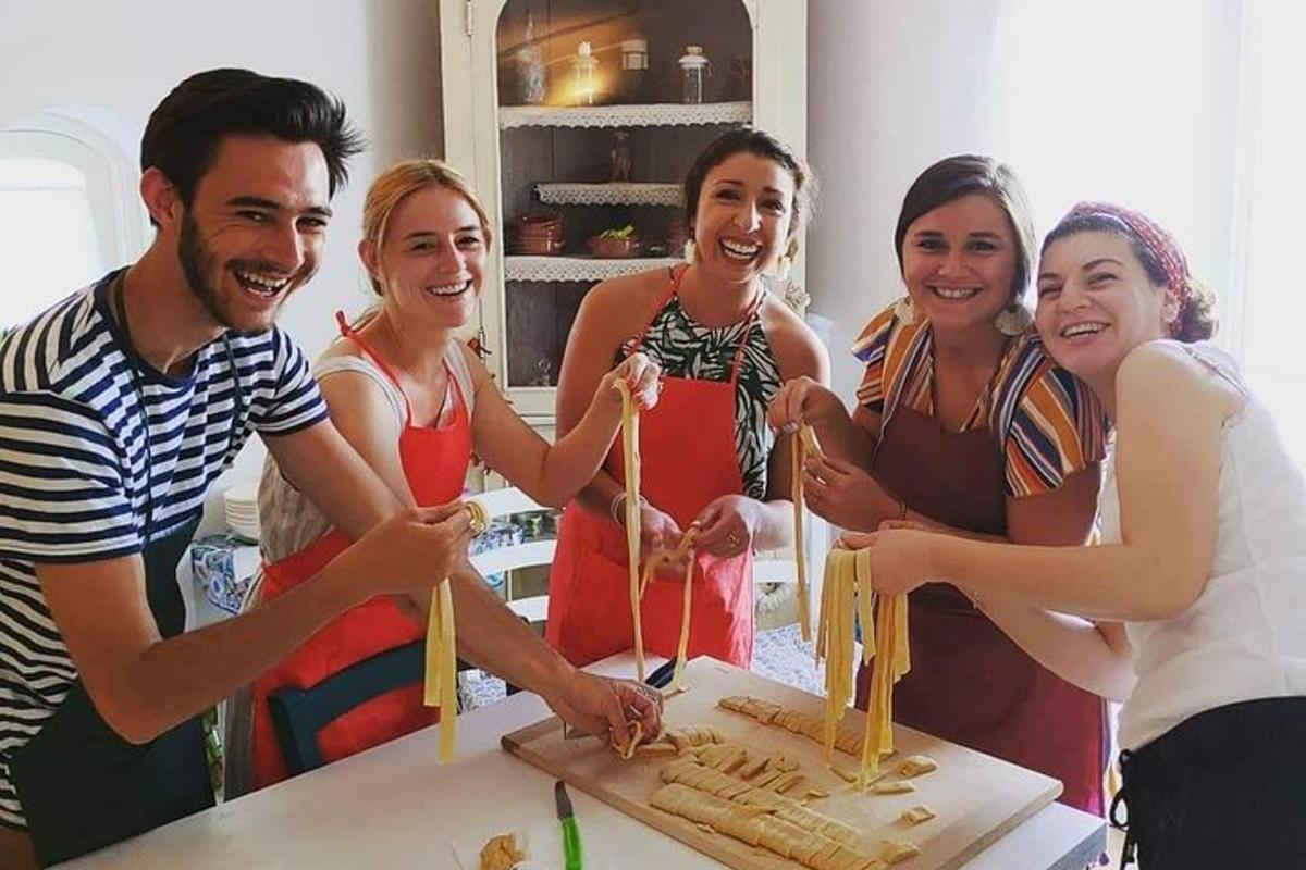 um grupo de pessoas em pé ao redor de uma mesa cortando um bolo