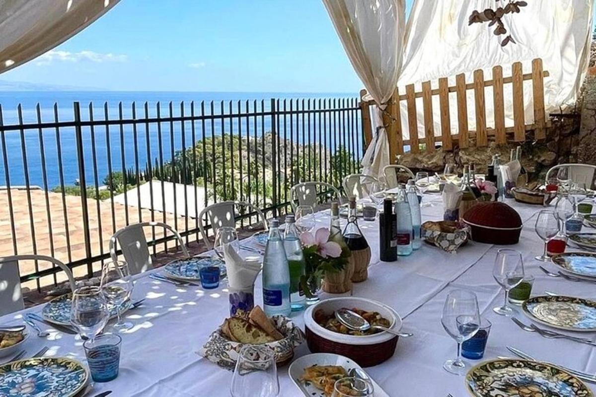 a table with plates of food and a view of the ocean