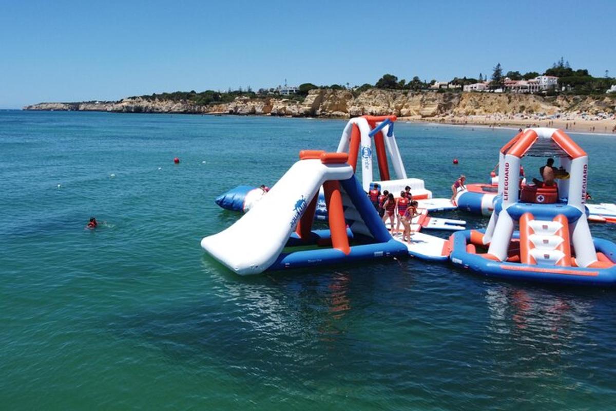 a group of kids playing on a water slide in the water