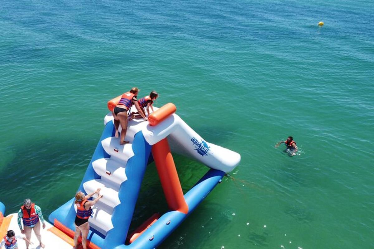 a group of people on an inflatable slide in the water