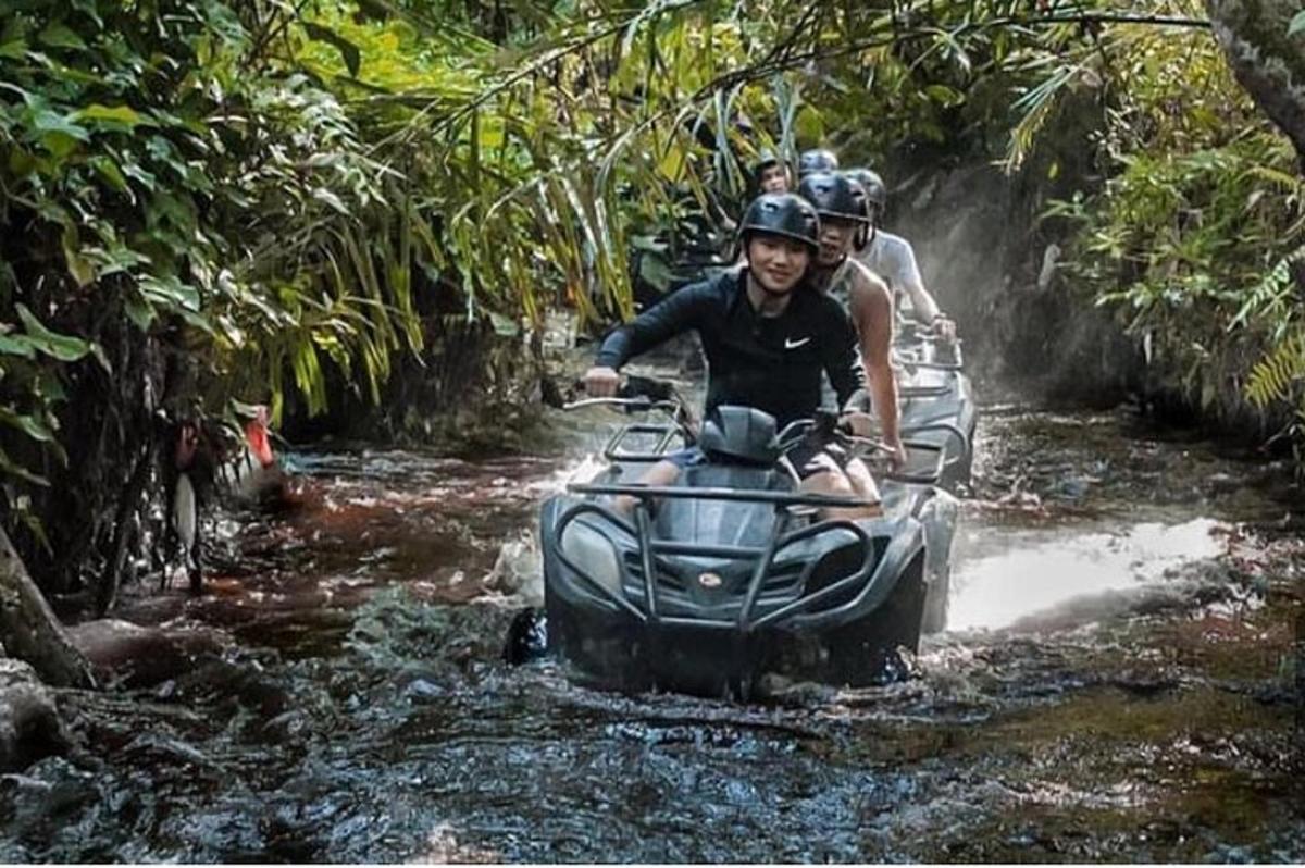 sekelompok orang mengendarai kendaraan roda empat melewati sungai