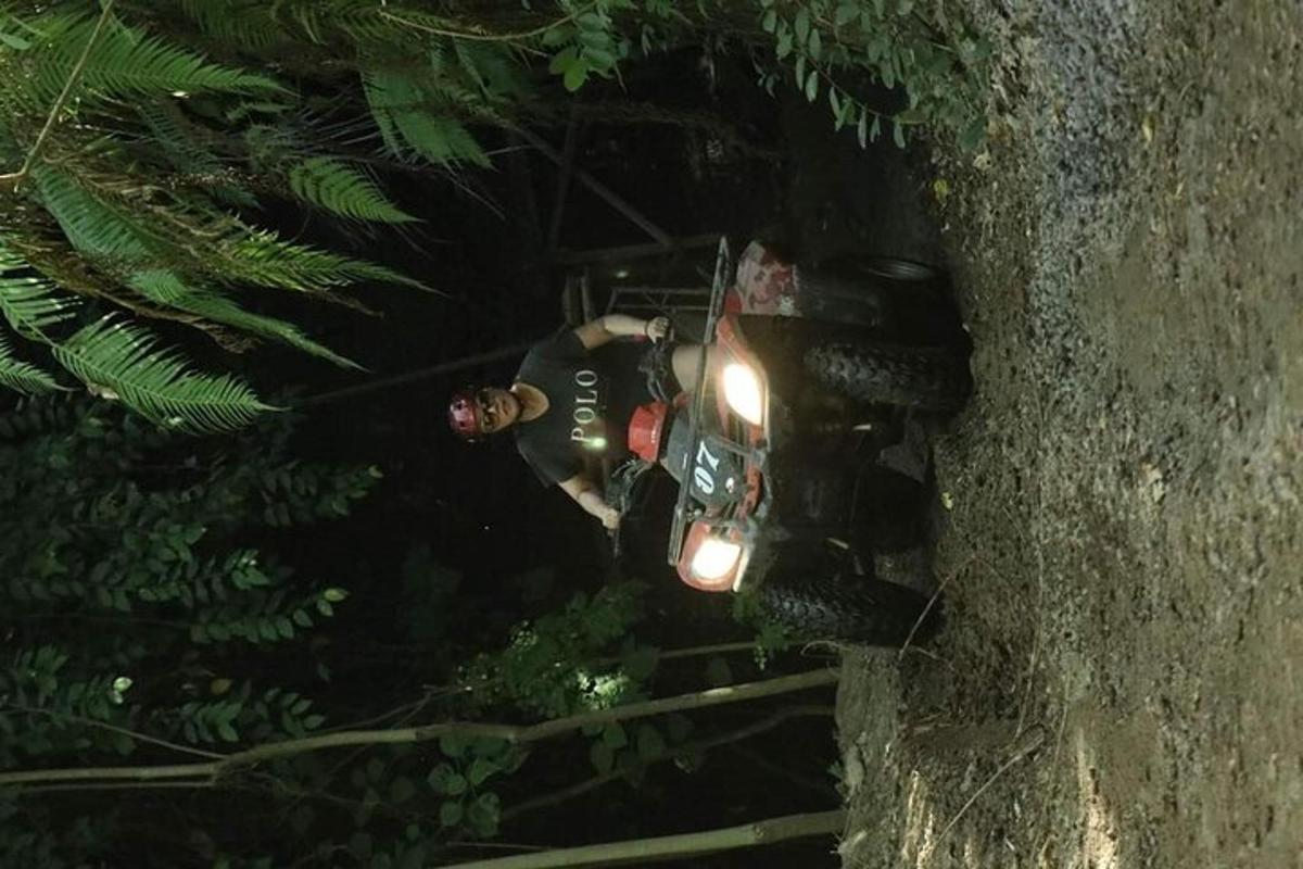 seorang pria berdiri di atas sepeda motor di malam hari
