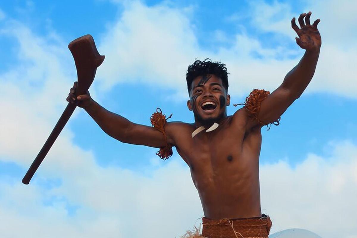un uomo a torso nudo che tiene in aria una pagaia