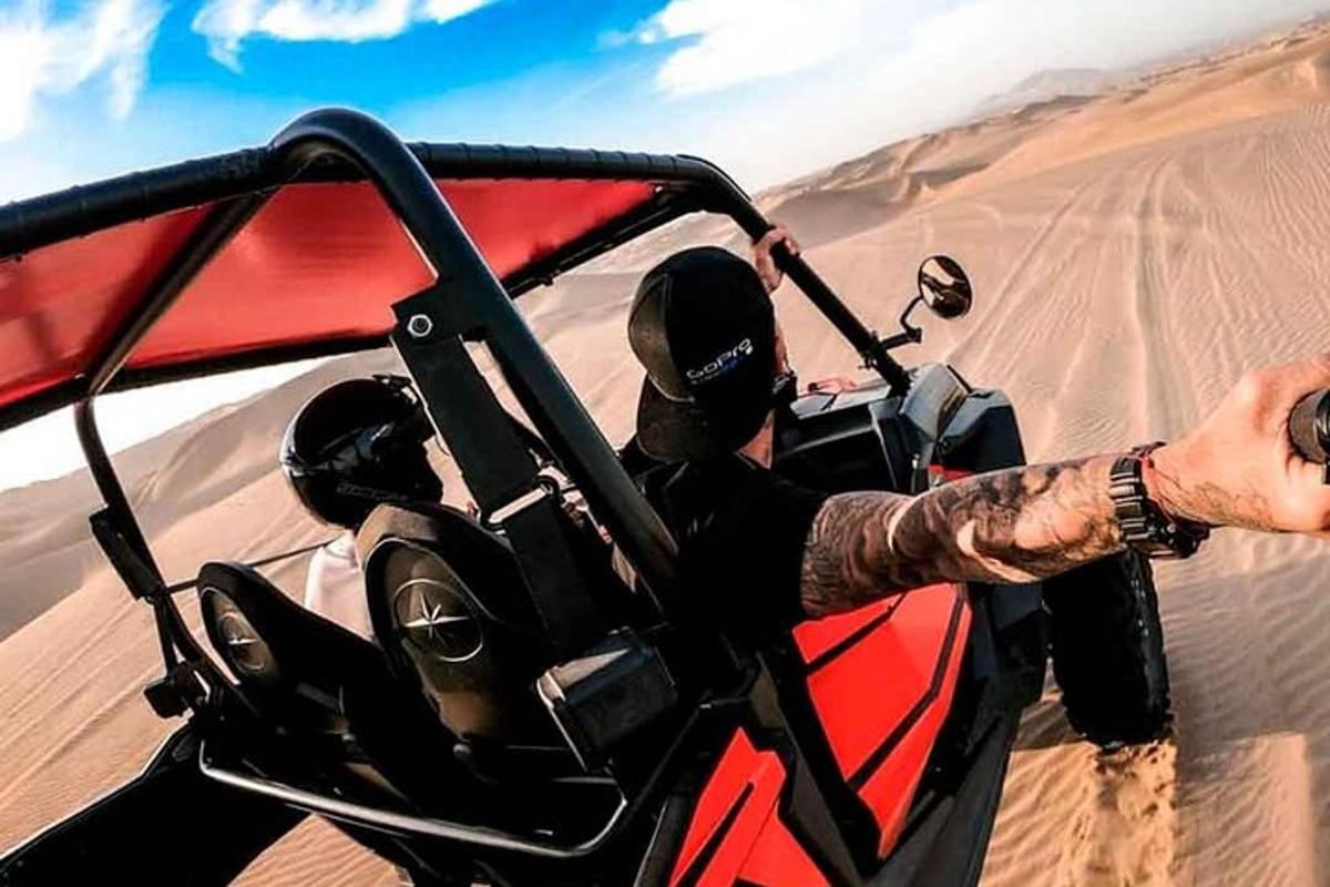 een man die op een motorfiets door de woestijn rijdt
