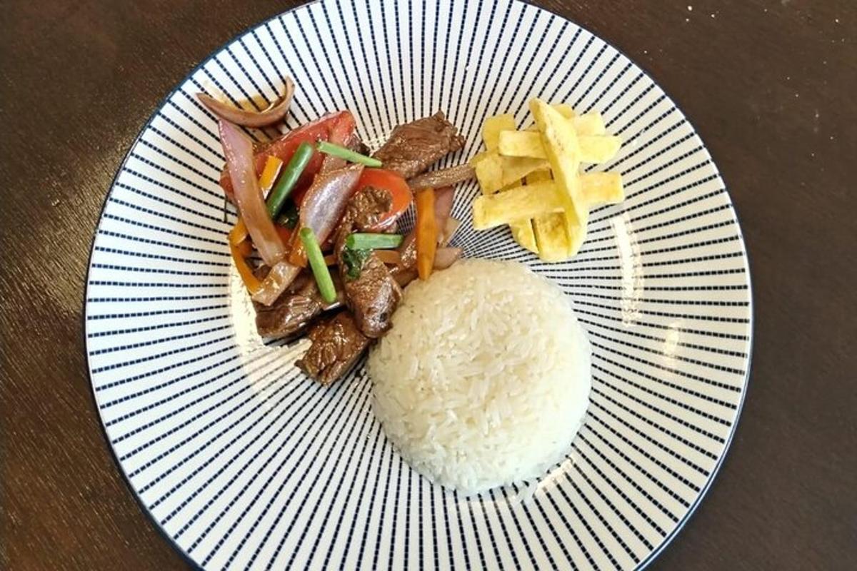 Un plato blanco con arroz, verduras y carne.