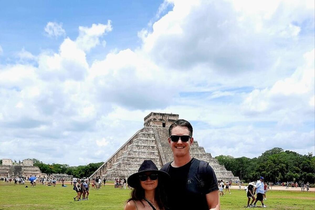 a man and woman standing in front of the pyramid