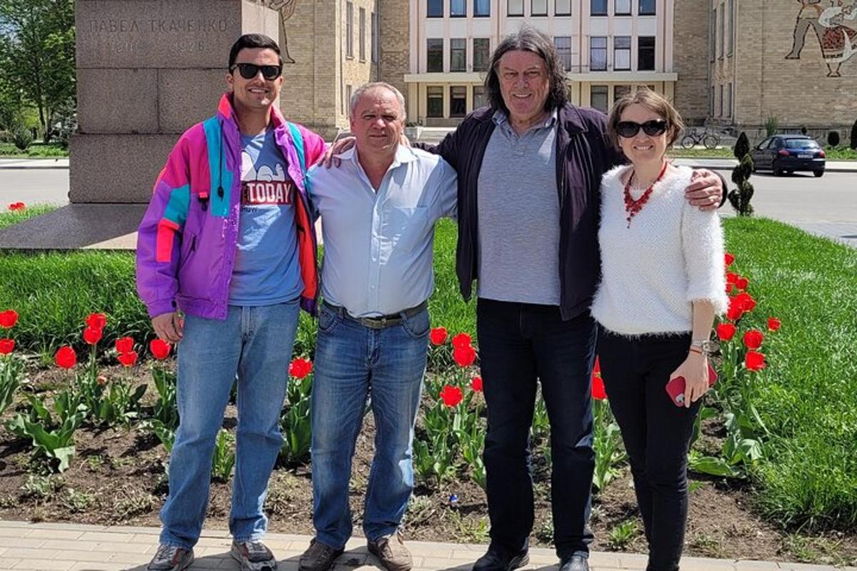 un gruppo di persone in posa per una foto davanti ai fiori