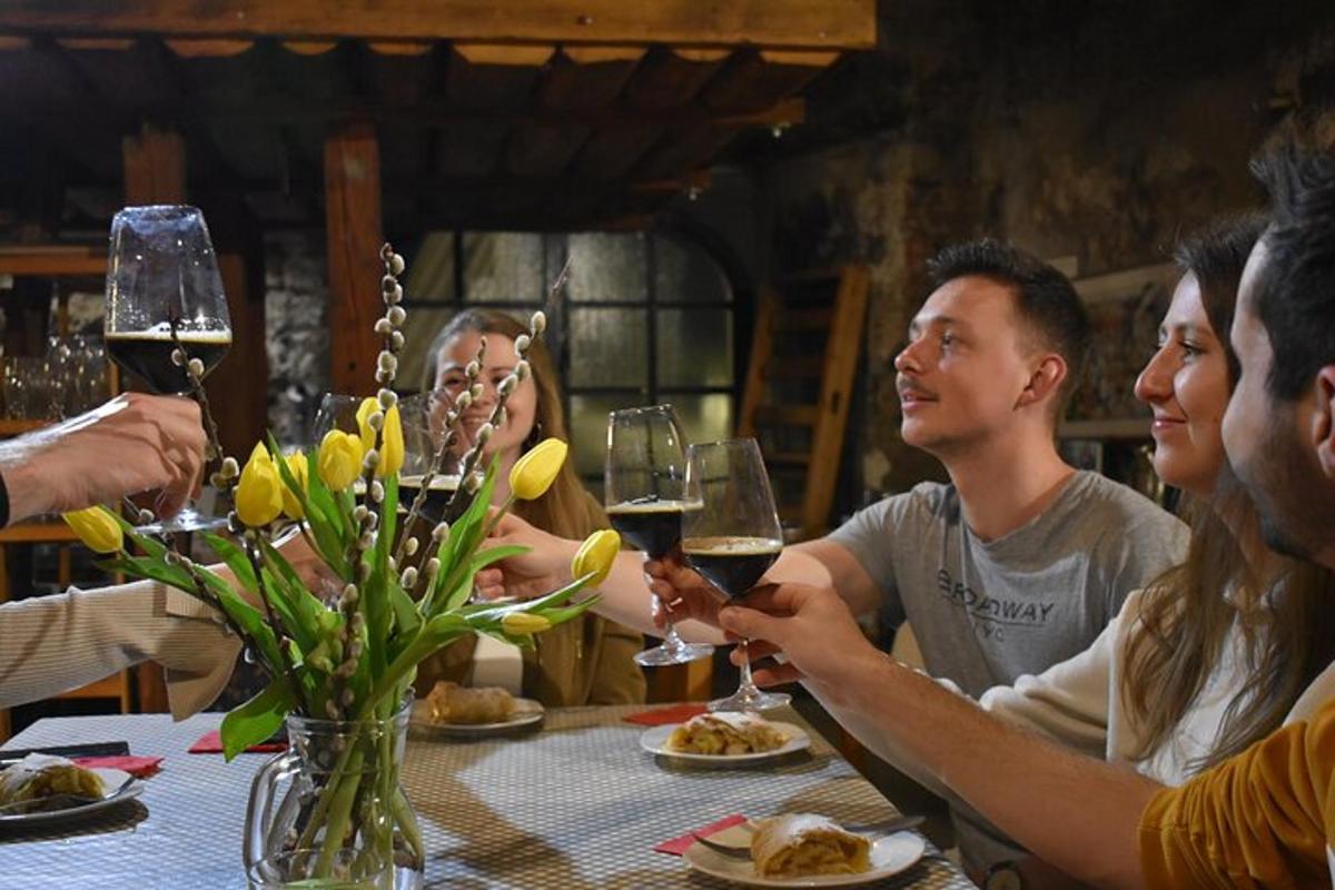 eine Gruppe von Menschen sitzt um einen Tisch und trinkt Wein