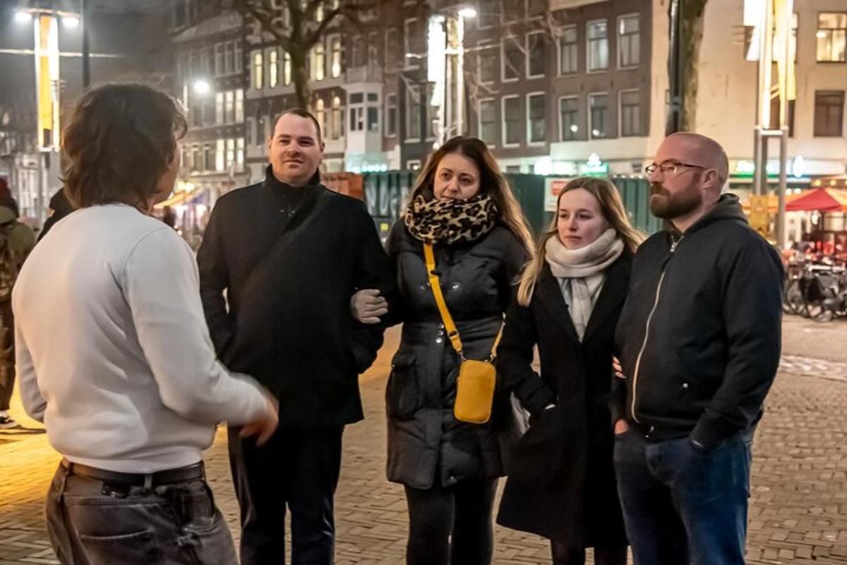 een groep mensen die 's nachts op straat staat