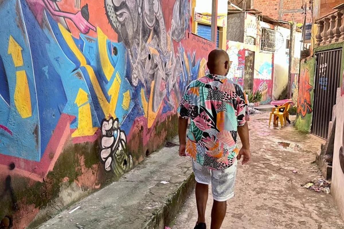 a man walking down a alley in front of a wall
