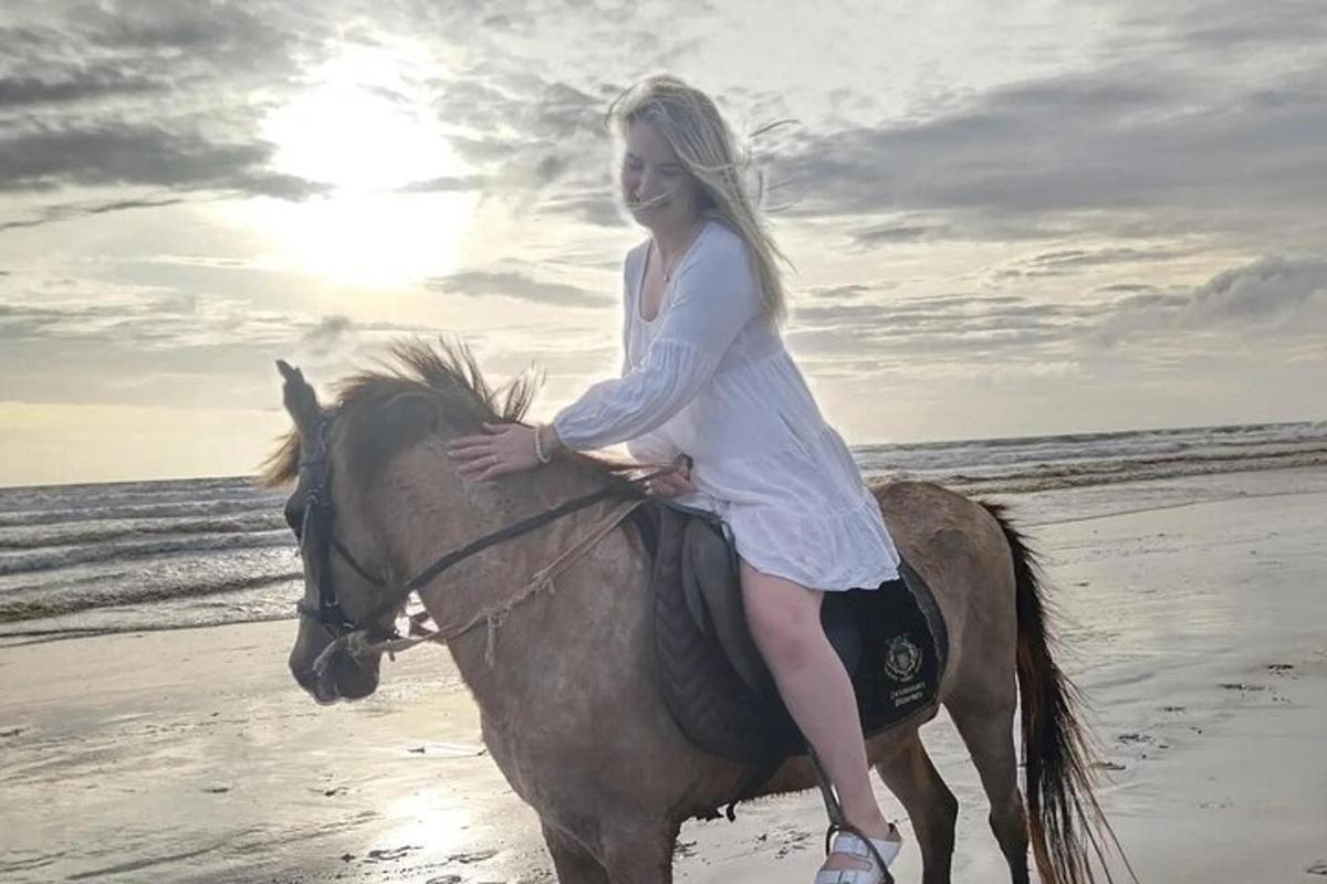 ženska, ki jaha konja na plaži