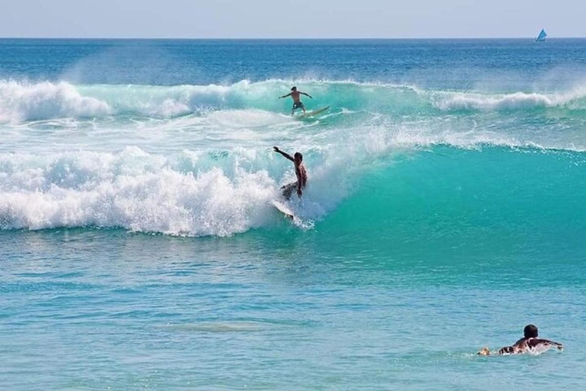 zwei Menschen reiten auf Surfbrettern im Meer auf einer Welle
