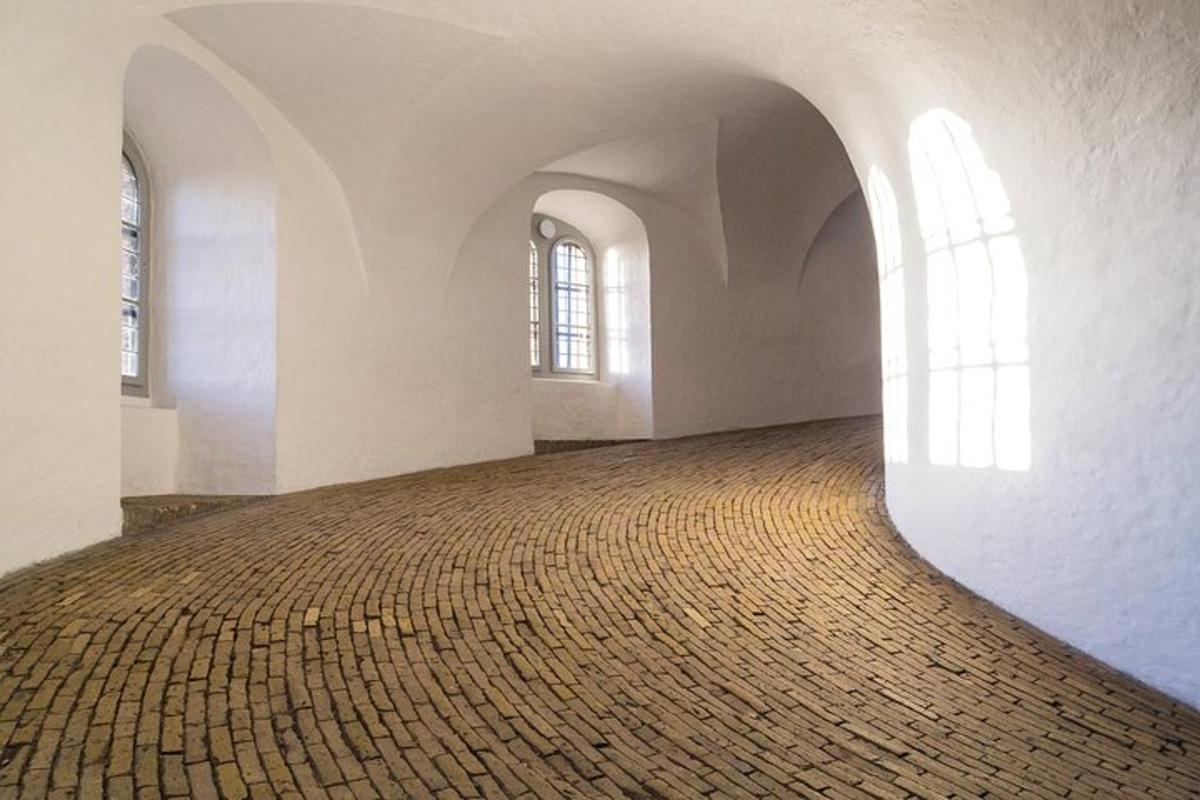 et tomt rom med to vinduer og et mursteinsgulv