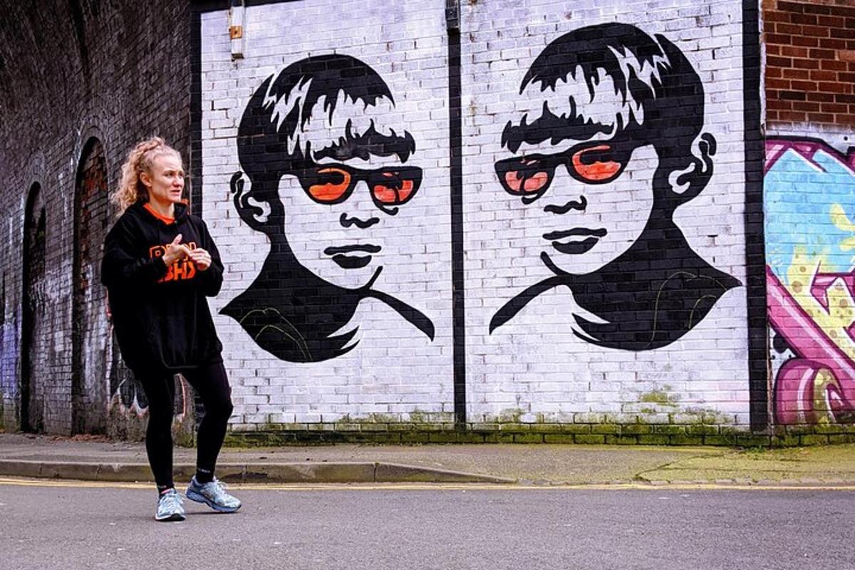 una donna in piedi davanti a un muro con un murale