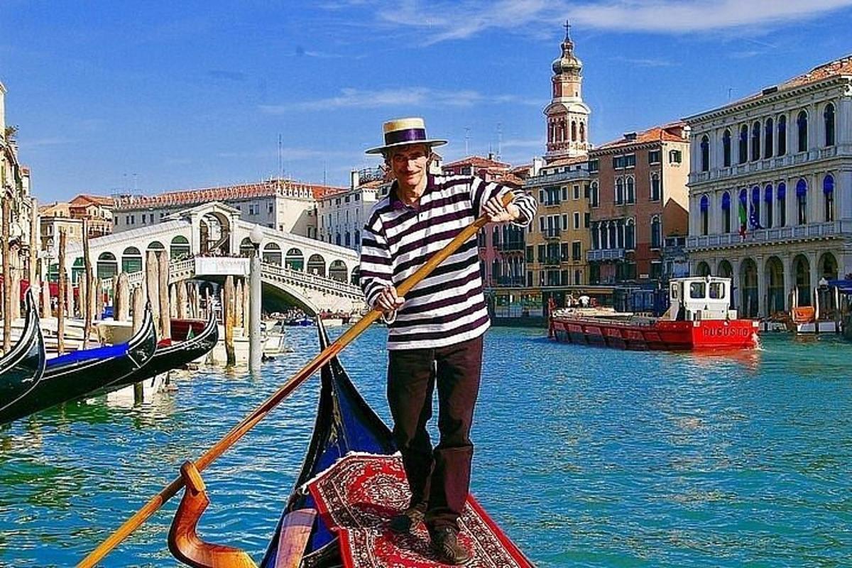 en mann padler i en gondol i en kanal