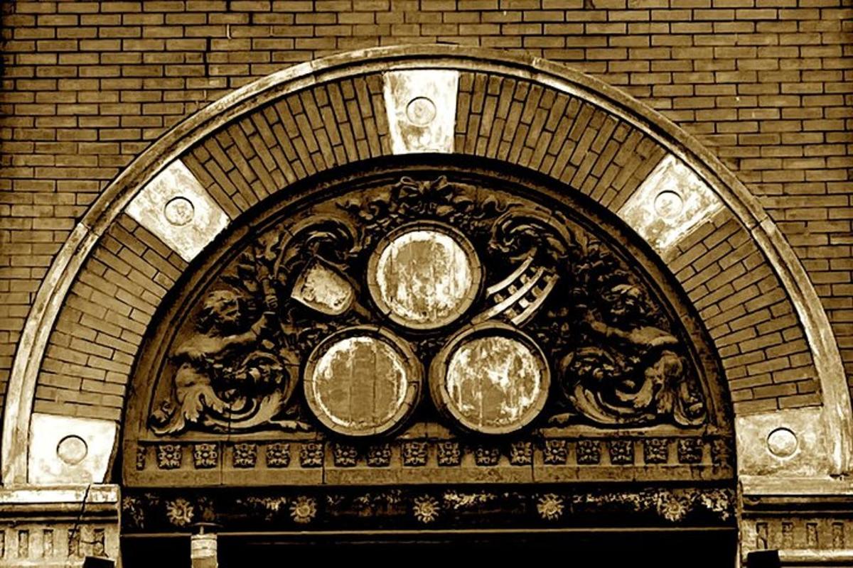 an archway with three plates on top of a building
