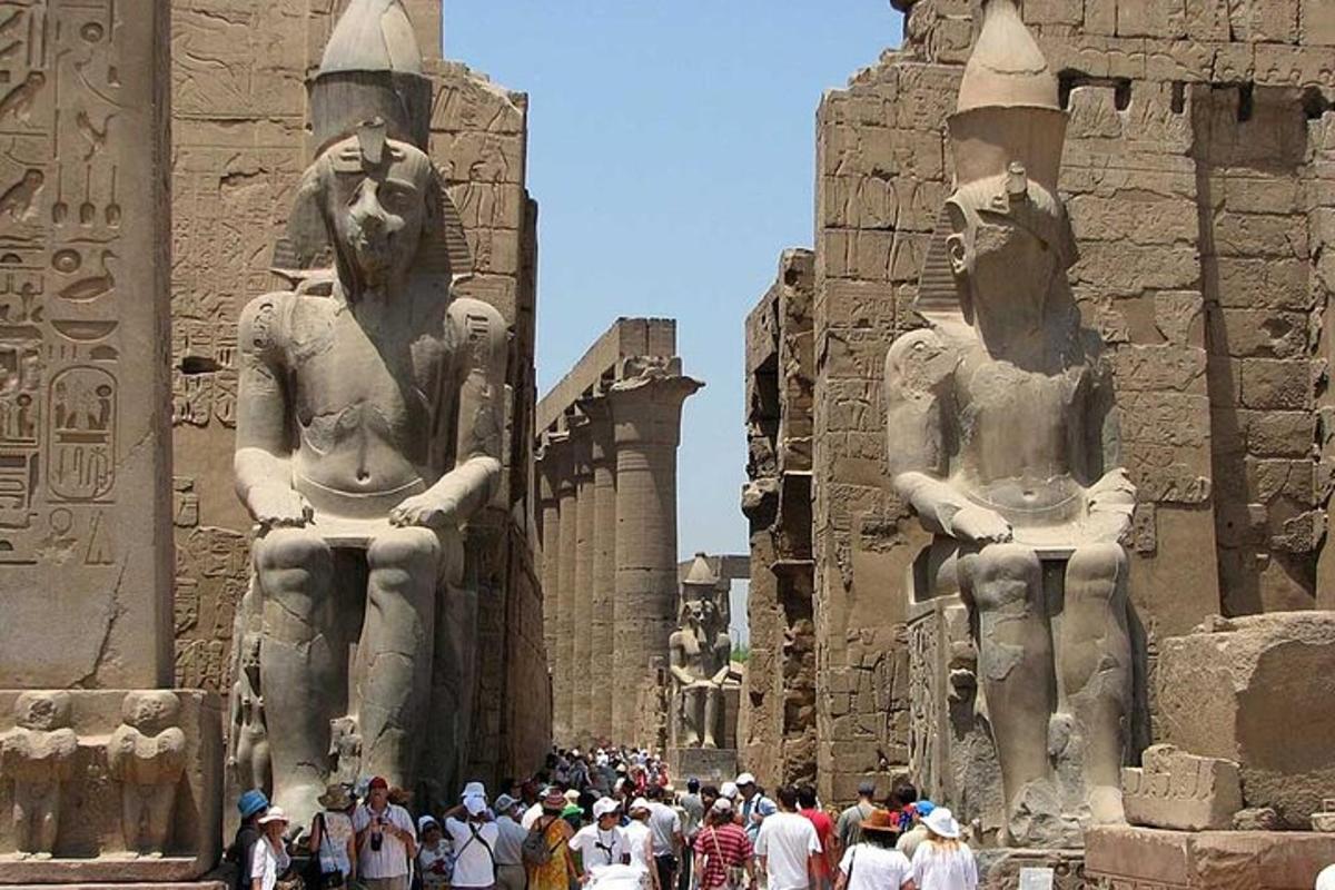 un gruppo di persone in piedi davanti a due statue