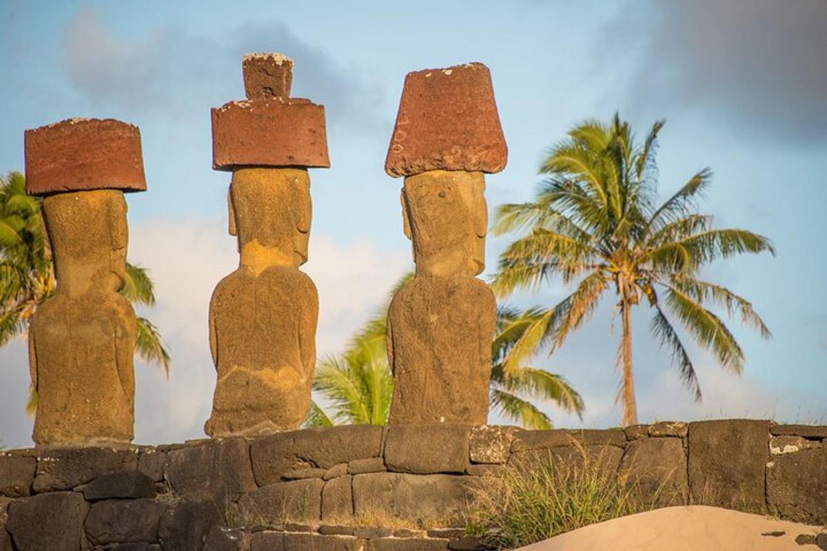 a group of three columns on a wall with a palm tree