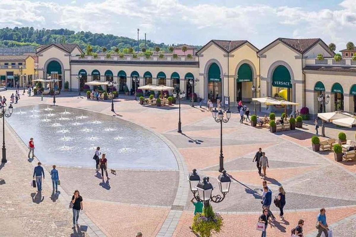 skupina lidí procházejících se kolem náměstí s fontánou