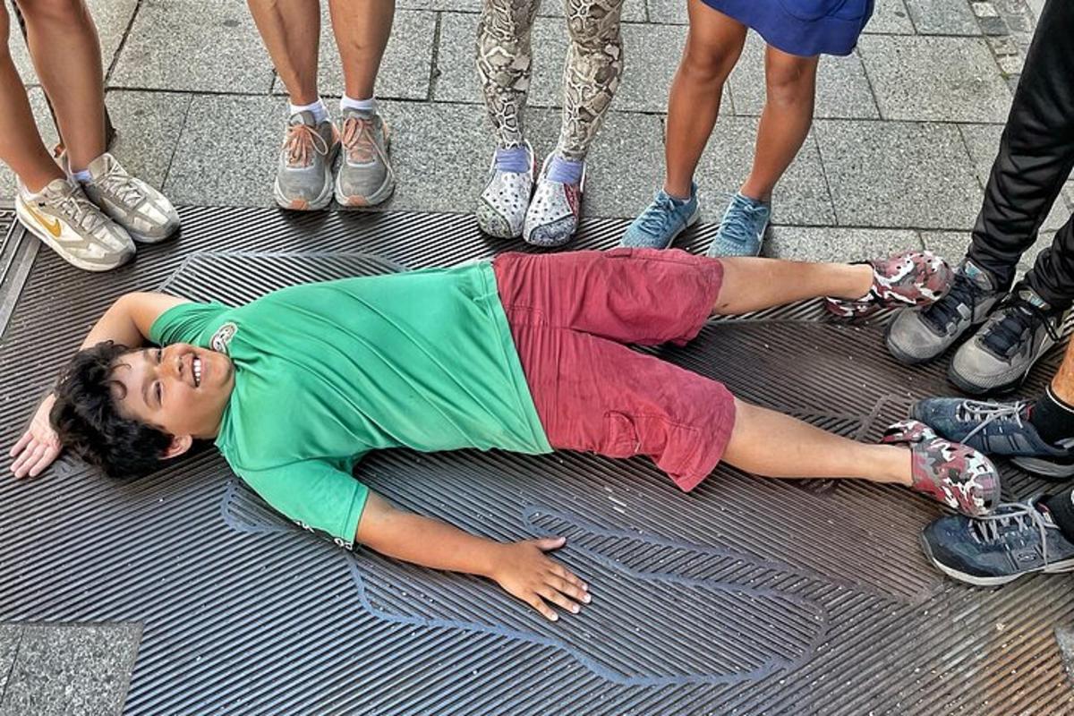 Una mujer tendida en el suelo frente a un grupo de personas.