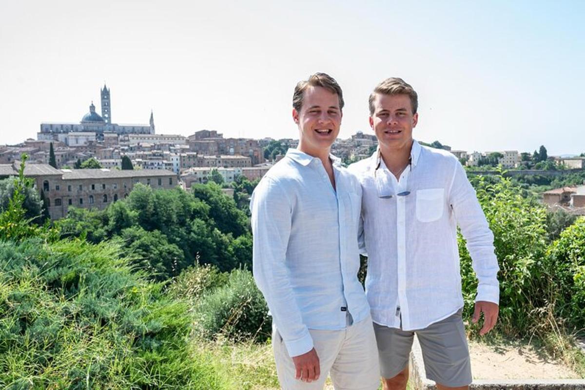 dois homens parados um ao lado do outro em frente a uma cidade