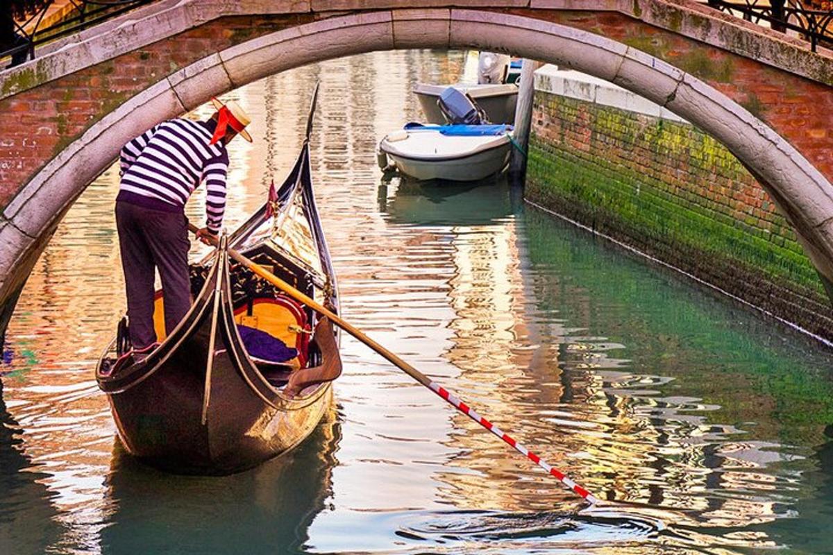 un uomo sta remando una gondola sotto un ponte
