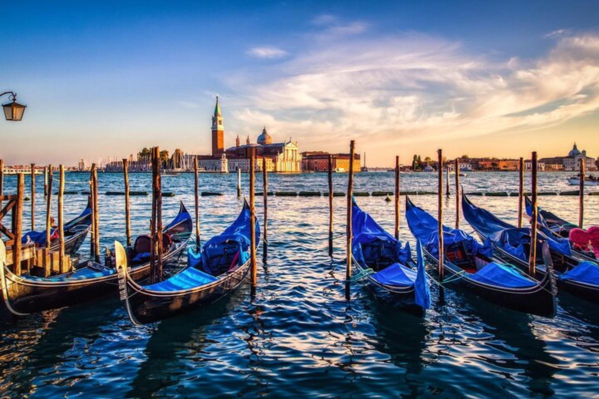 một nhóm thuyền gondola trên mặt nước với một thành phố ở phía sau