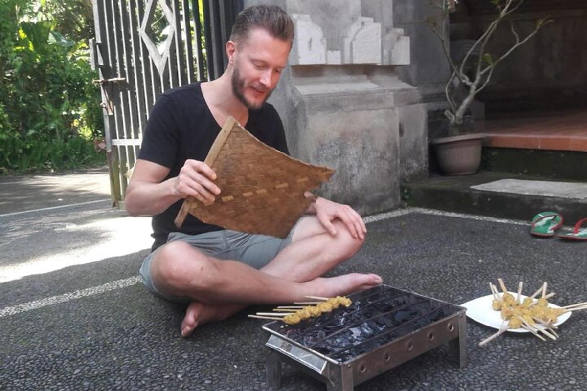 moški sedi na tleh poleg žara