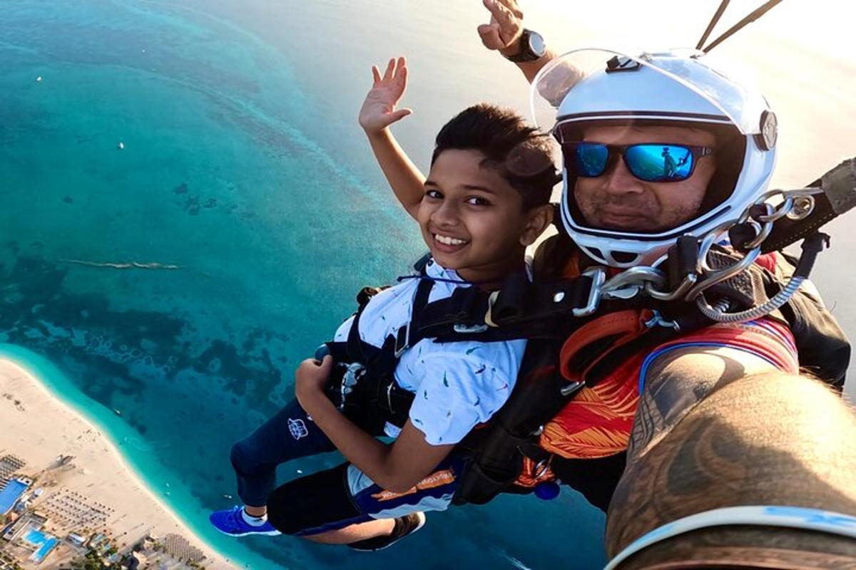 seorang lelaki dan seorang kanak-kanak menaiki zipline di atas air