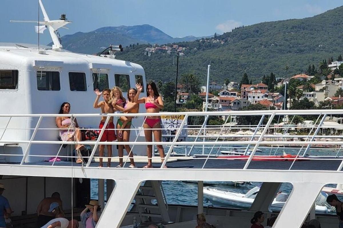 skupina deklet, ki stojijo na boku čolna