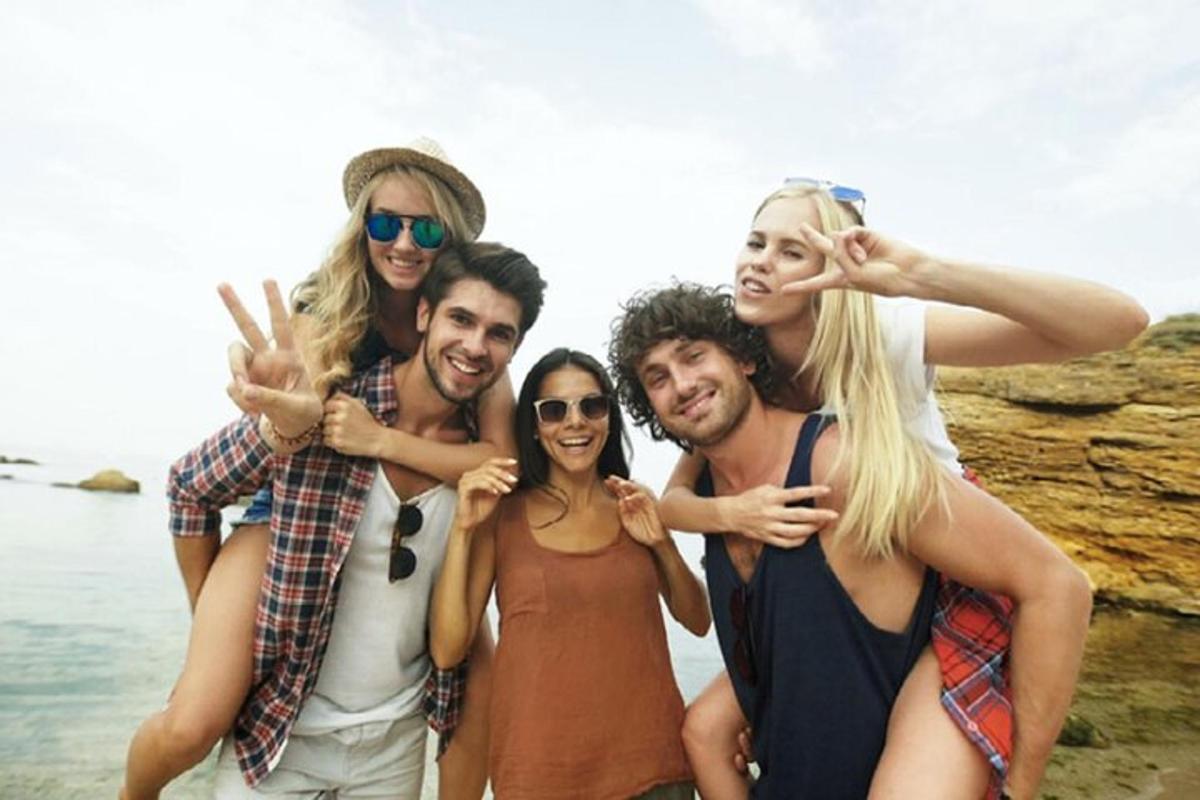 um grupo de pessoas posando para uma foto na praia