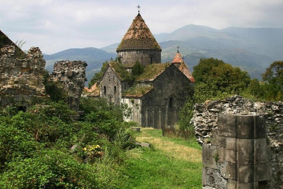 eine alte Kirche auf einem Hügel mit Bergen im Hintergrund