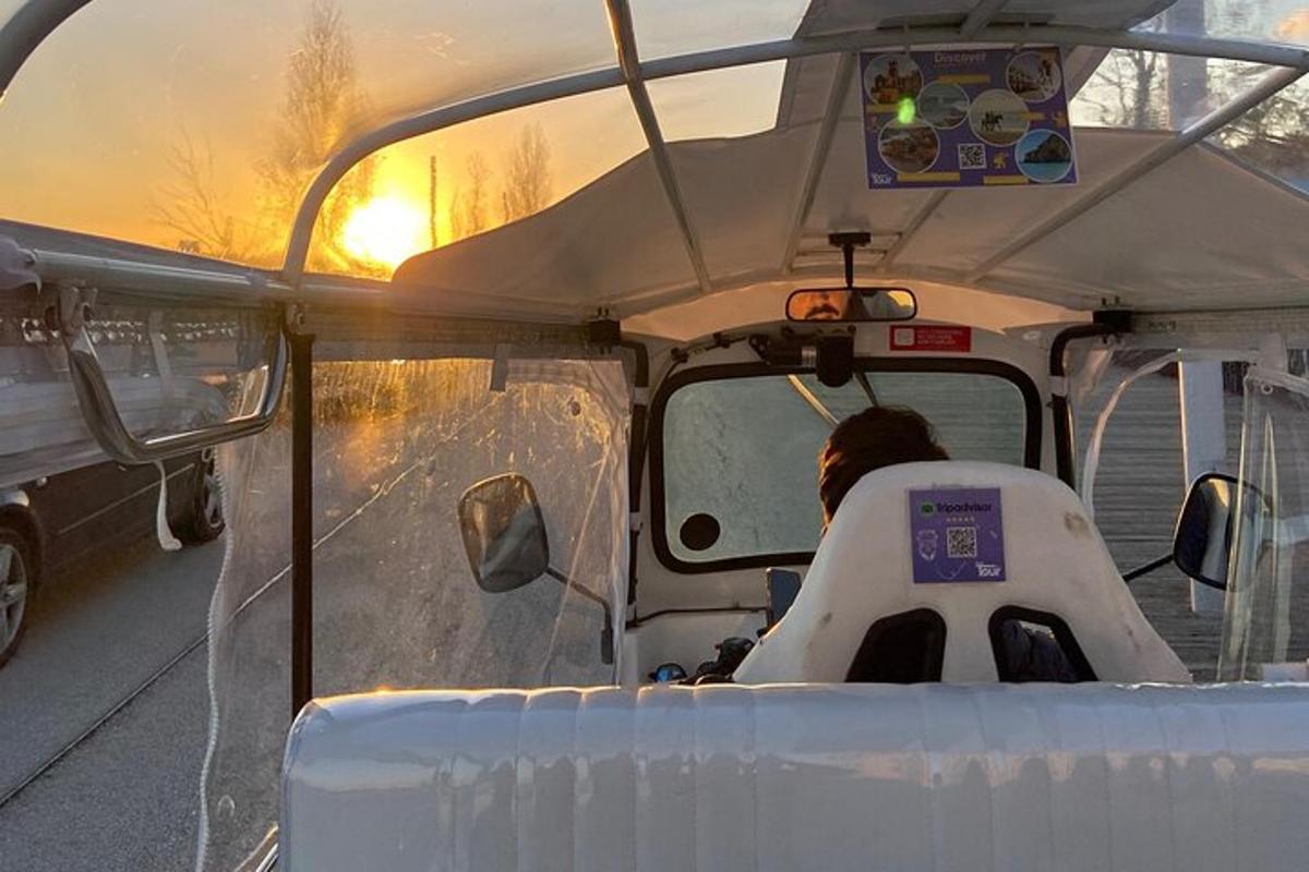 maður að keyra golfbíl á veginum