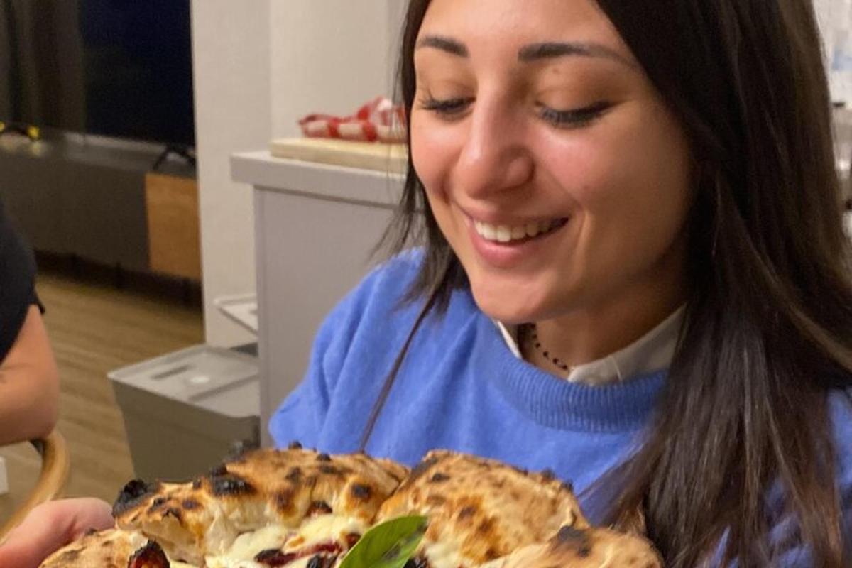 Kona brosir á meðan hún horfir á pizzu
