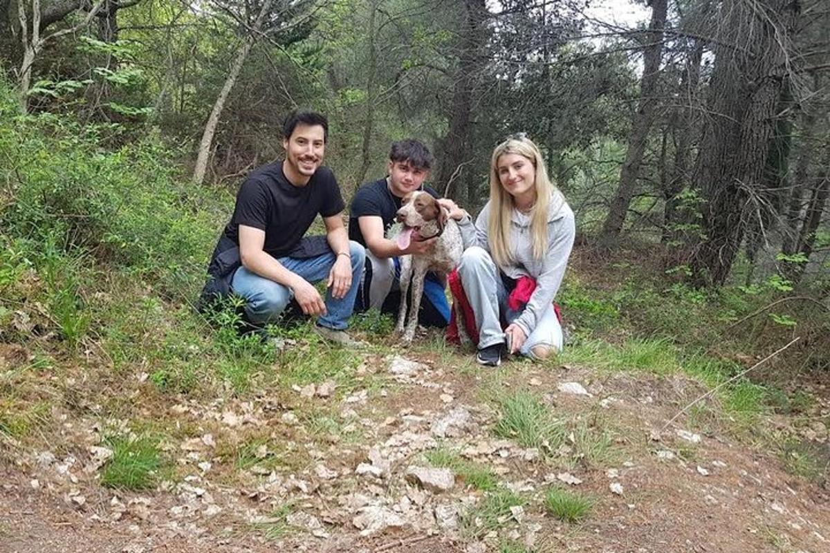 en gruppe mennesker som kneler på en høyde med en hund