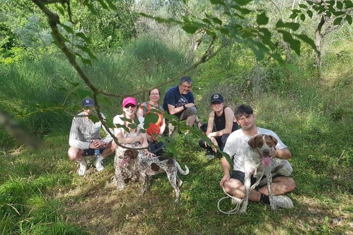 en gruppe mennesker som sitter i gresset med en hund
