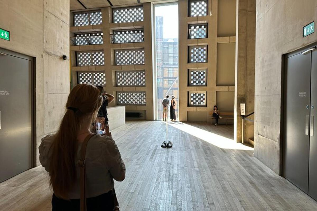 uma mulher tirando uma foto de uma sala em um prédio