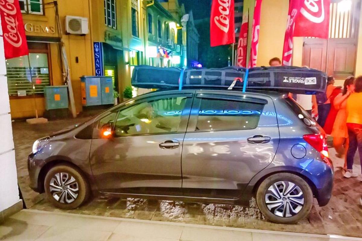 una piccola auto parcheggiata su una strada cittadina di notte