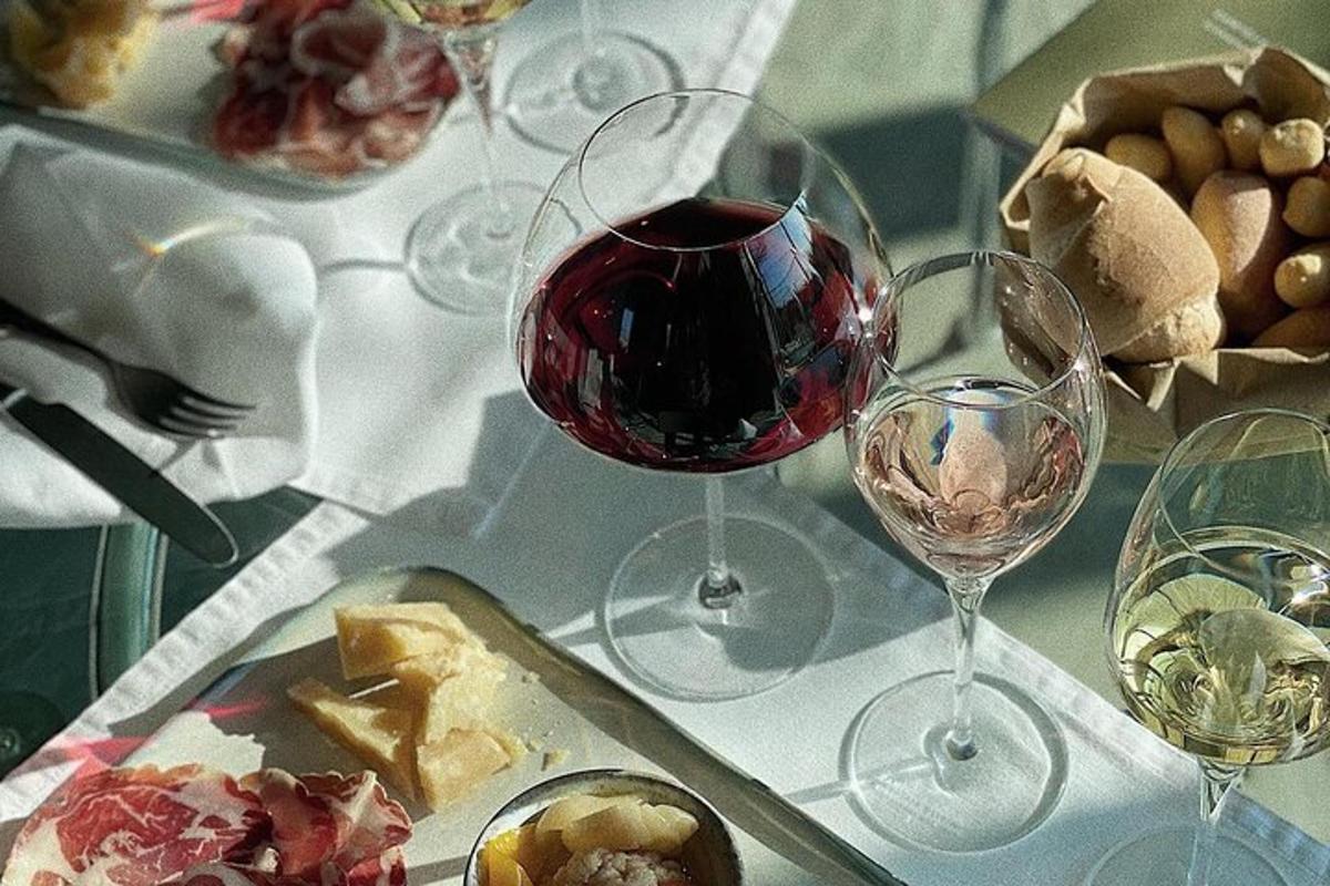 un tavolo con due bicchieri di vino e un piatto di cibo